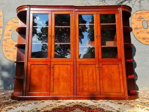 Large display cabinet with four glass doors, side shelves, and four cabinets at the bottom