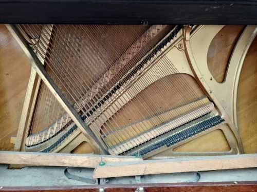 Danemann upright piano in teak cabinetry is a brilliant upright piano