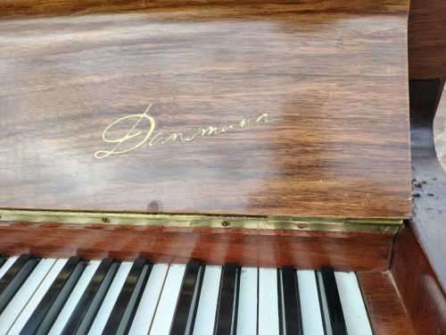 Danemann upright piano in teak cabinetry is a brilliant upright piano