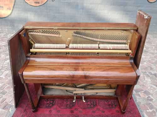 Danemann upright piano in teak cabinetry is a brilliant upright piano
