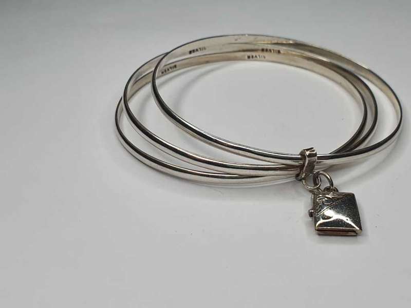 Trio of sterling silver bangles with a locket