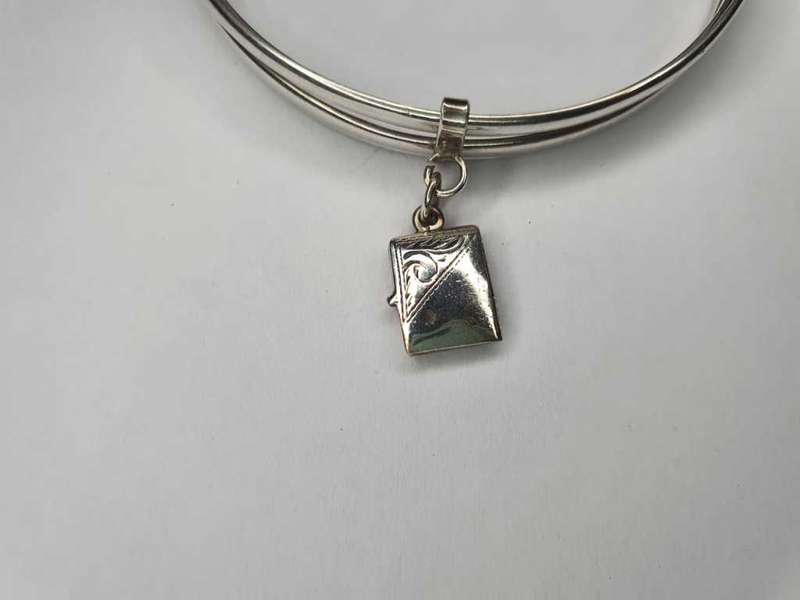 Trio of sterling silver bangles with a locket