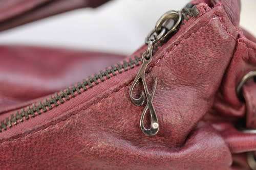 GENUINE JENNIFER LOPEZ (JLO) BURGUNDY ORIGINAL LEATHER 'HOBO' HANDBAG WITH TASSEL DETAILS.
