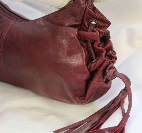 GENUINE JENNIFER LOPEZ (JLO) BURGUNDY ORIGINAL LEATHER 'HOBO' HANDBAG WITH TASSEL DETAILS.