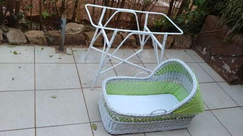 Lovely white cane bassinet on a stand.