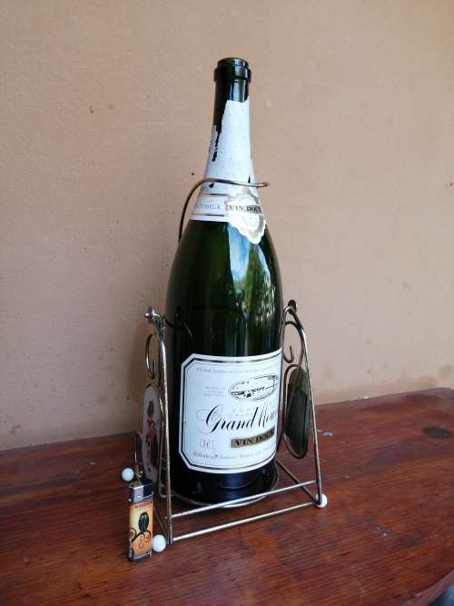 Large Grand Mousseux champagne bottle on a stand.