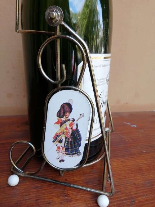 Large Grand Mousseux champagne bottle on a stand.