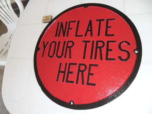 large and heavy cast aluminium inflate your tires here sign