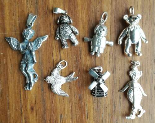 Collection of 7 Silver bracelet charms. One bid takes all.