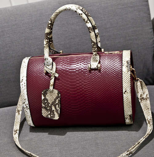 Snake pattern pillow shape handbag. Wine red color. Have a strape