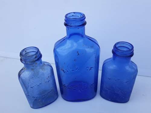 Light blue embossed MILK OF MAGNESIA vintage bottles