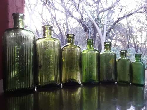 Seven green POISON NOT TO BE TAKEN bottles