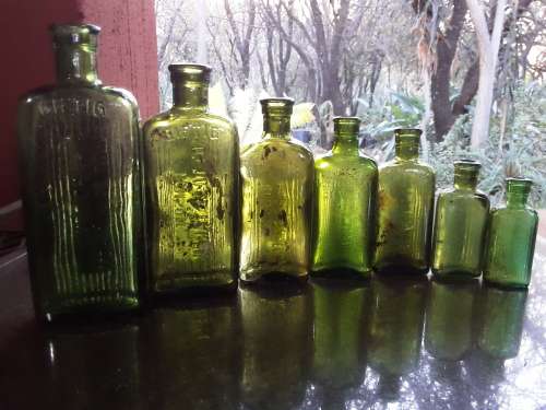 Seven green POISON NOT TO BE TAKEN bottles
