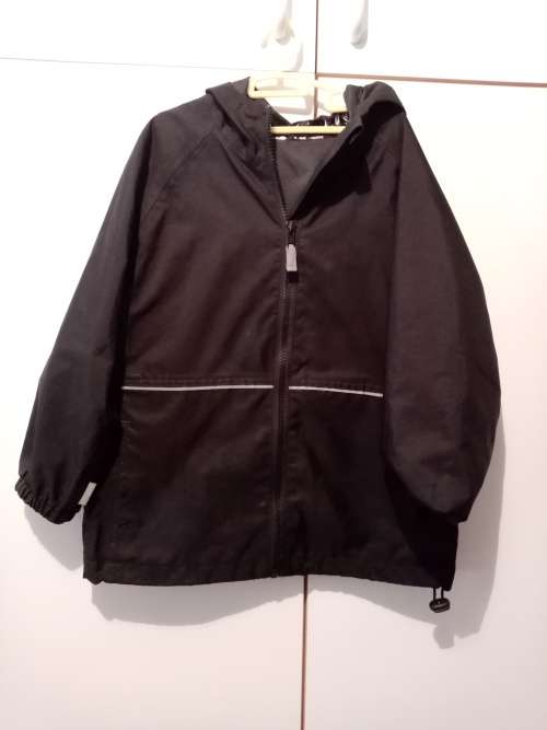 Black Woolworths rain jacket 5-6 with reflector strips and large zipped pocket at back