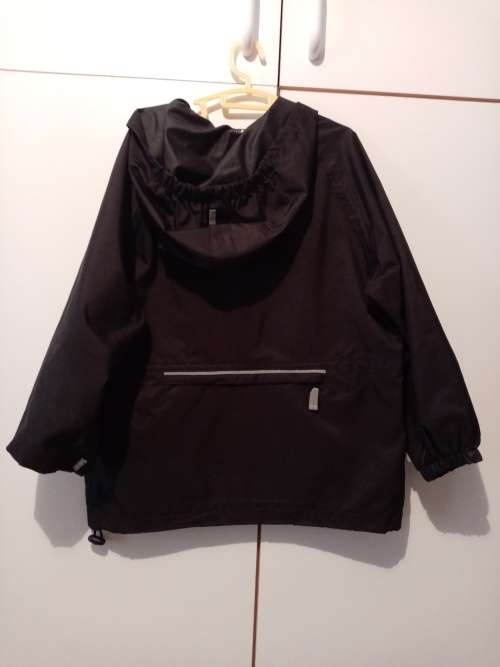 Black Woolworths rain jacket 5-6 with reflector strips and large zipped pocket at back