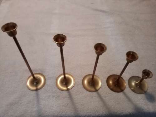 Five brass candle holders in various sizes