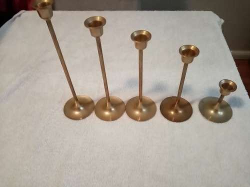 Five brass candle holders in various sizes
