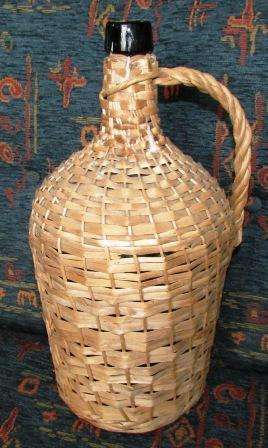 Vintage green Demi John bottle with cane casing. Approx. 40cmh x 20cm d