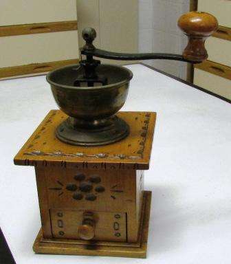 Antique coffee grinder on wooden box. Approx. 15cmh
