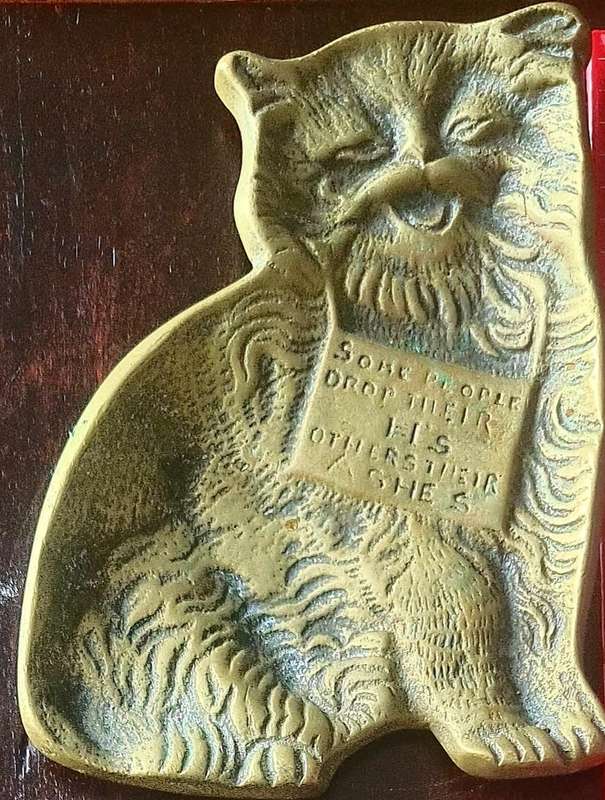 A lovely vintage brass flat cat ashtray with and embellished sign `Some people drop their H`s others