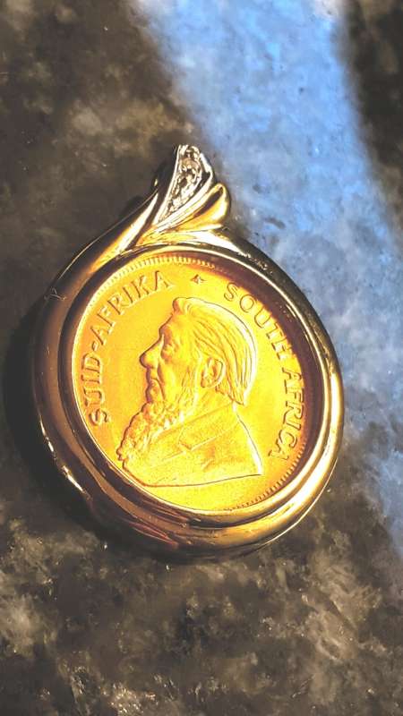 1/ 10 th KRUGERRAND SET IN  A 9 CT PENDANT  WITH A DIAMOND