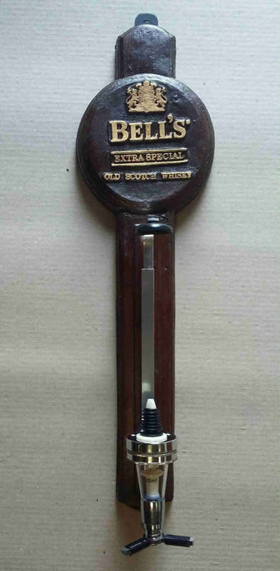 Single optic spirit tot measure dispenser on bell`s backing. Wall hanging.