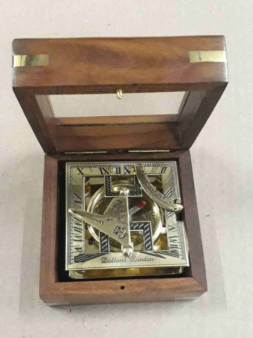 Brass sundial compass in a wooden glass box