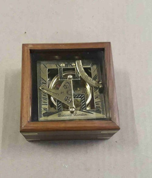 Brass sundial compass in a wooden glass box