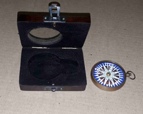 Brass compass in a solid wooden box with a floating dial.