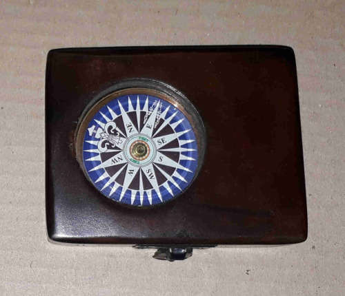 Brass compass in a solid wooden box with a floating dial.
