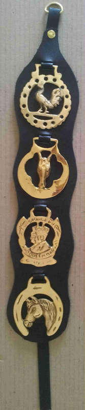 4 horse brasses on black leather strap                                                   nb11