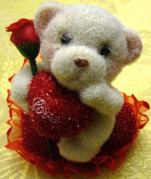 CUTE BEAR HOLDING A ROSE AND A HEART SITTING ON A HEART CUSHION