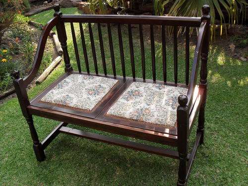THIS IS AN EXTREMELY APPEALING DOUBLE SEATER SPINDLE BACK STAINED WOOD BENCH WITH UPHOLSTERY