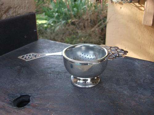 QUITE NICE SILVER PLATED TEA STRAINER & HOLDER.