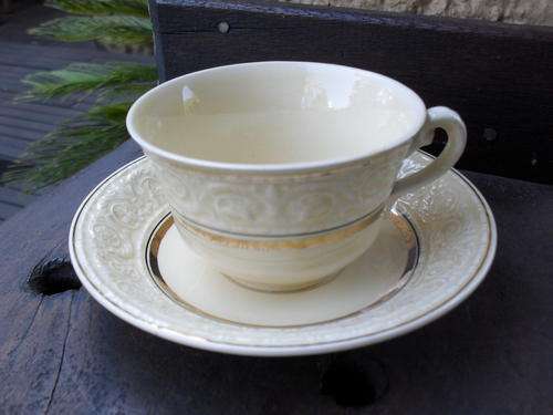 CROWN DEVON TEA DUO......PALE YELLOW WITH RAISED FLORAL AND OTHER DETAIL AND GOLD TRIM