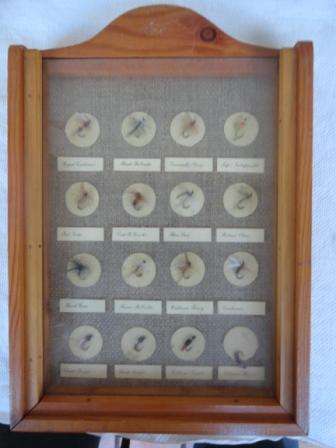 Sixteen flyfishing hooks encased in an attractive display behind glass