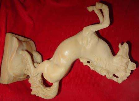 A moulded "ivory " looking  prancing horse