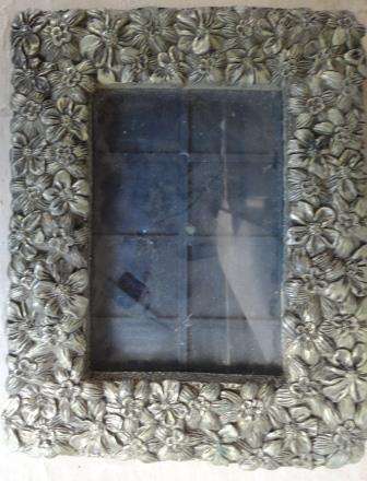 A vintage highly floral ornate solid metal photo frame with back anchor.