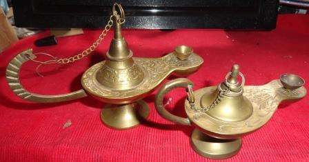 A pair of brass lamps with different designs on each