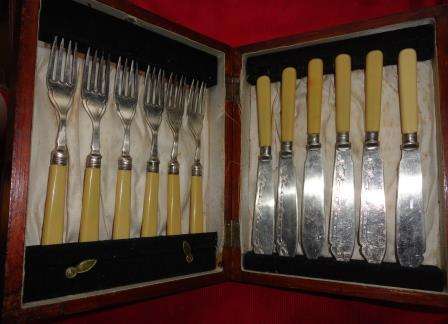 An oak boxed set of bone handle silver plated fork and knives