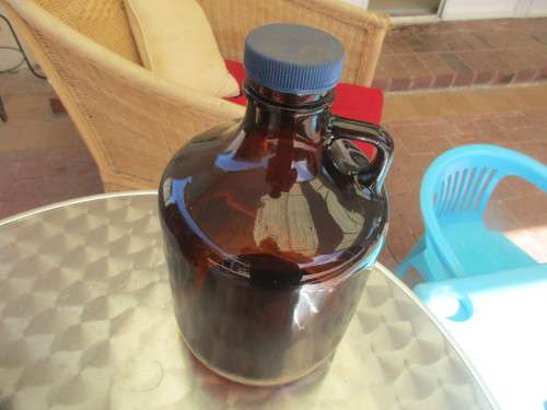 TWO BROWN GLASS DEMIJOHNS RED AND BLUE TOPS