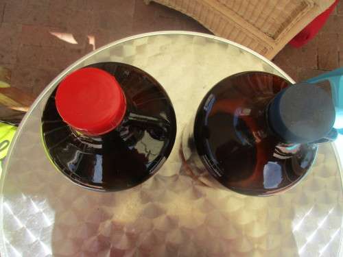 TWO BROWN GLASS DEMIJOHNS RED AND BLUE TOPS