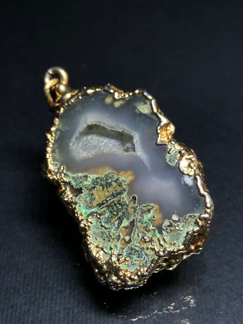 A BESPOKE GREY AGATE PENDANT WITH GOLD GILDED EDGING