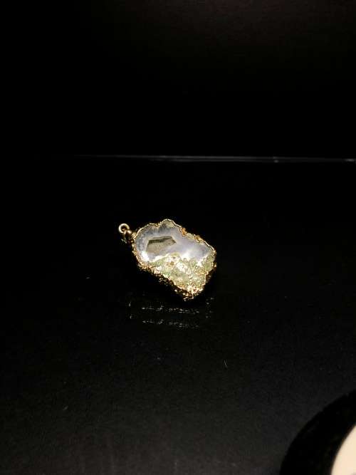 A BESPOKE GREY AGATE PENDANT WITH GOLD GILDED EDGING