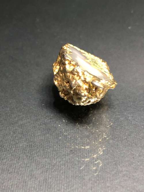 A BESPOKE GREY AGATE PENDANT WITH GOLD GILDED EDGING
