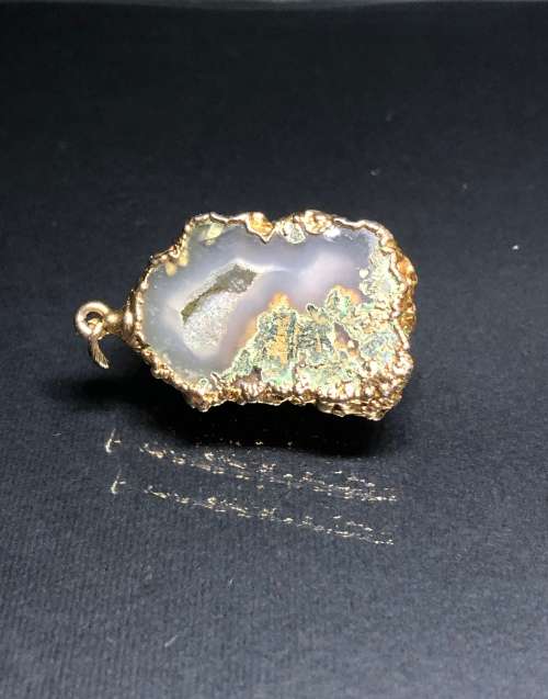 A BESPOKE GREY AGATE PENDANT WITH GOLD GILDED EDGING