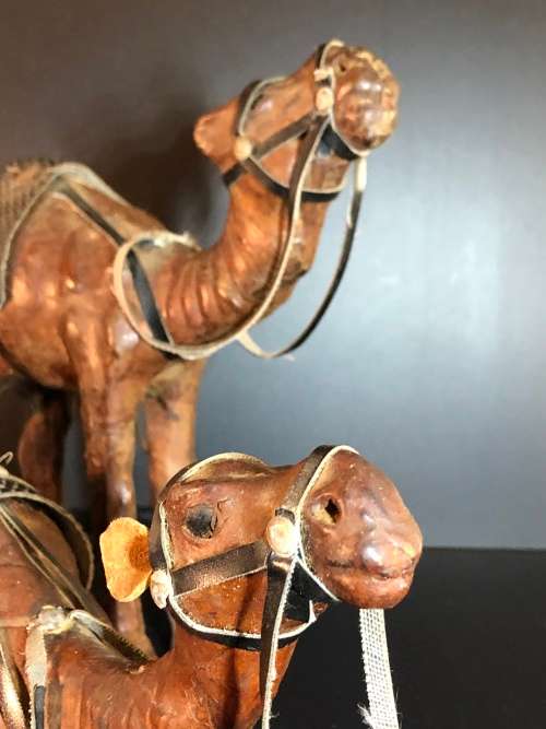 A PAIR OF MORROCAN LEATHER CAMEL FIGURINES