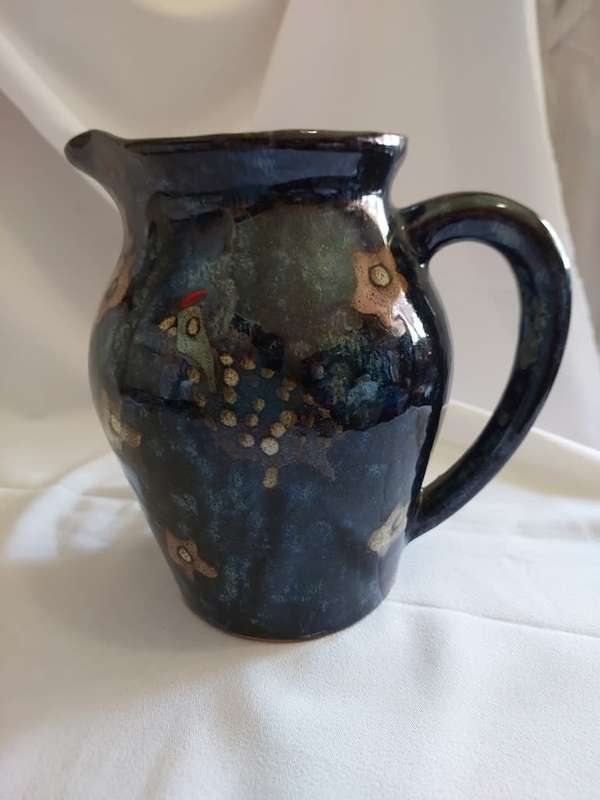 A hand painted lustre pottery jug with guinea fowl