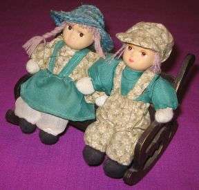 PORCELAIN DOLLS ON A ROCKING BENCH