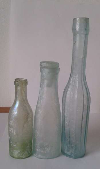 Three vintage bottles - fluted sauce, aqua bottle with glass stopper, and little green bottle